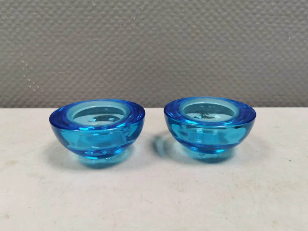Un ensemble de porte-bougies iittala en verre transparent bleu.