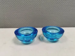 Un ensemble de porte-bougies iittala en verre transparent bleu.