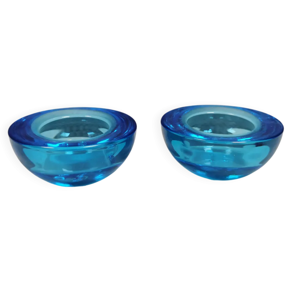 Un ensemble de porte-bougies iittala en verre transparent bleu.