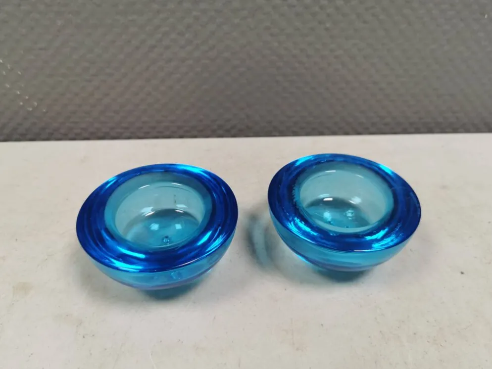 Un ensemble de porte-bougies iittala en verre transparent bleu.